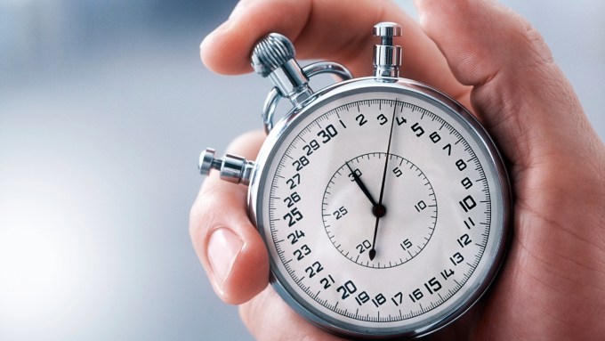 A hand holds a stop watch